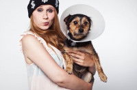 Une femme tient un petit chien malade dans ses bras