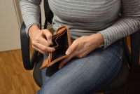 Une femme en manque d'argent regarde son porte-monnaie vide