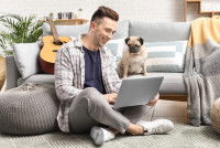 Un homme et un chien regardent un ordinateur
