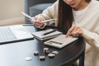 Une femme comptant de l'argent à l'aide d'une calculatrice