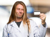 Une ostéopathe tenant sa carte de credit en main