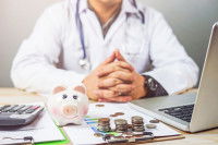 Un vétérinaire devant une tirelire et des pièces de monnaie
