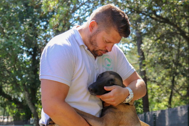 L'éducateur canin Eric Tramson serrant un chien contre lui