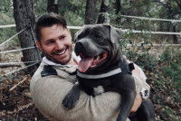 L'éducateur canin Eric Tramson portant un chien dans ses bras