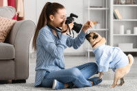 Une femme qui essaye d'attirer l'attention de son chien pour le prendre en photo