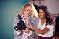 Une photographe montre à une femme les photos prises avec son appareil photo