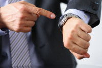 Un homme pointe sa montre du doigt