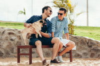 Deux hommes assis sur un banc avec un chien