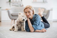 Une femme fait un câlin à son Westie dans son salon