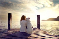 Une femme et son chien sur un ponton