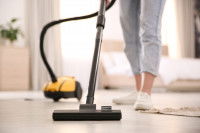 Une femme passe l'aspirateur dans le salon