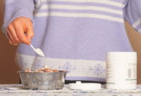 Une femme ajoute un complément alimentaire à la gamelle de son chien