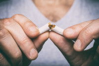 Un homme brise une cigarette en deux