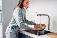 Une femme lave la gamelle de son chien