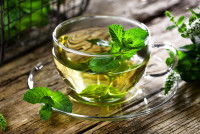 Un thé à la menthe dans une tasse posé sur une table