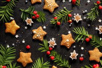 Des biscuits de Noël et des branches d'if sur un fond noir