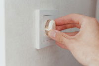 Une femme pose une protection sur une prise électrique