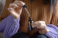 Une femme tenant un flacon de fleurs de Bach