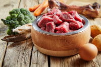 Toutes sortes d'aliments crus pour chien sur une table en bois