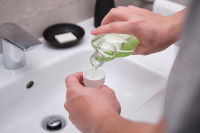 Un homme verse un bain de bouche dans un gobelet