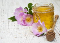 Un pot de miel posé à côté de fleurs