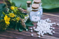 Des granules d'homéopathie à côté de plantes