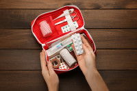 Une femme met des médicaments dans la trousse de secours