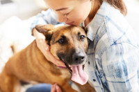 Une femme serrant son chien dans ses bras