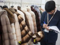 Un homme examinant des manteaux de fourrure