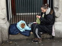 Une femme sans-abri tricotant dans la rue avec son chien