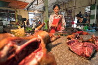 Une bouchère au Vietnam préparant de la viande de chien