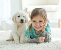 Une fillette couché à côté d'un chiot