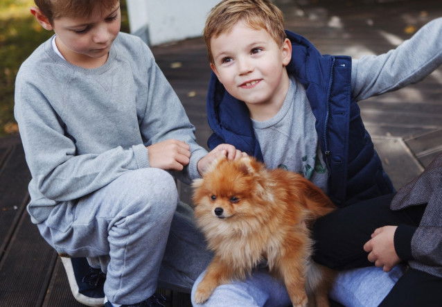 Deux enfants caressent un chiot