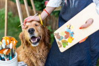 Une femme peintre fait un câlin à son chien