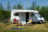 Un couple âgé assis devant un camping-car