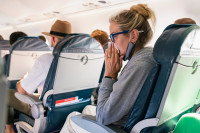 Une femme se mouchant dans un avion