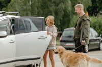 Une famille avec un chien rentre dans la voiture