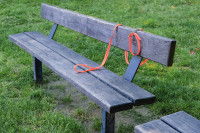 Une laisse de chien posée sur un banc dans un parc