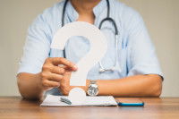 Un médecin tient un point d'interrogation dans sa main