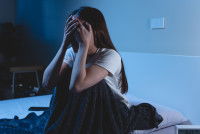 Une femme triste pleure sur son lit