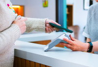 Une femme paye dnas une clinique avec son téléphone