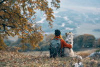 Une femme et son chien en randonnée en montagne pendant l'automne