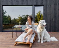 Une femme sur une chaise longue à côté de son chien