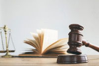 La balance de la justice, un maillet et un livre de droit posés sur un bureau