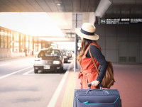 Un femme attendant un taxi à la sortie de l'aéroport