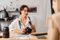 Une photographe, appareil photo à la main, discutant du contrat avec sa cliente