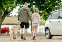 Un homme avec son enfant et un chien se rendent jusqu'à un lac