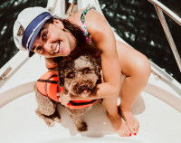 Une propriétaire enlace son chien sur un bateau