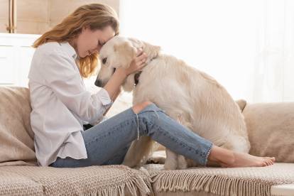 Une jeune femme pose son front contre le crâne de son Golden Retriever