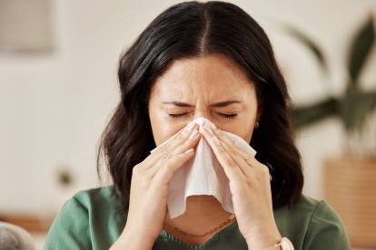 Une femme éternuant dans un mouchoir